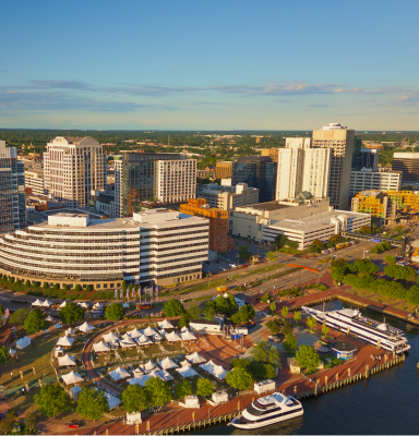 Norfolk: Aerial view of a city skyline and waterfront harbor with boats.