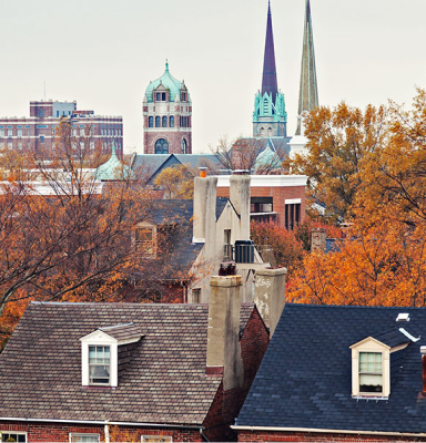 Portsmouth: Historic city rooftops and church spires framed by autumn trees.