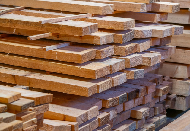 Close-up of neatly stacked rough-sawn wooden planks in a workshop.